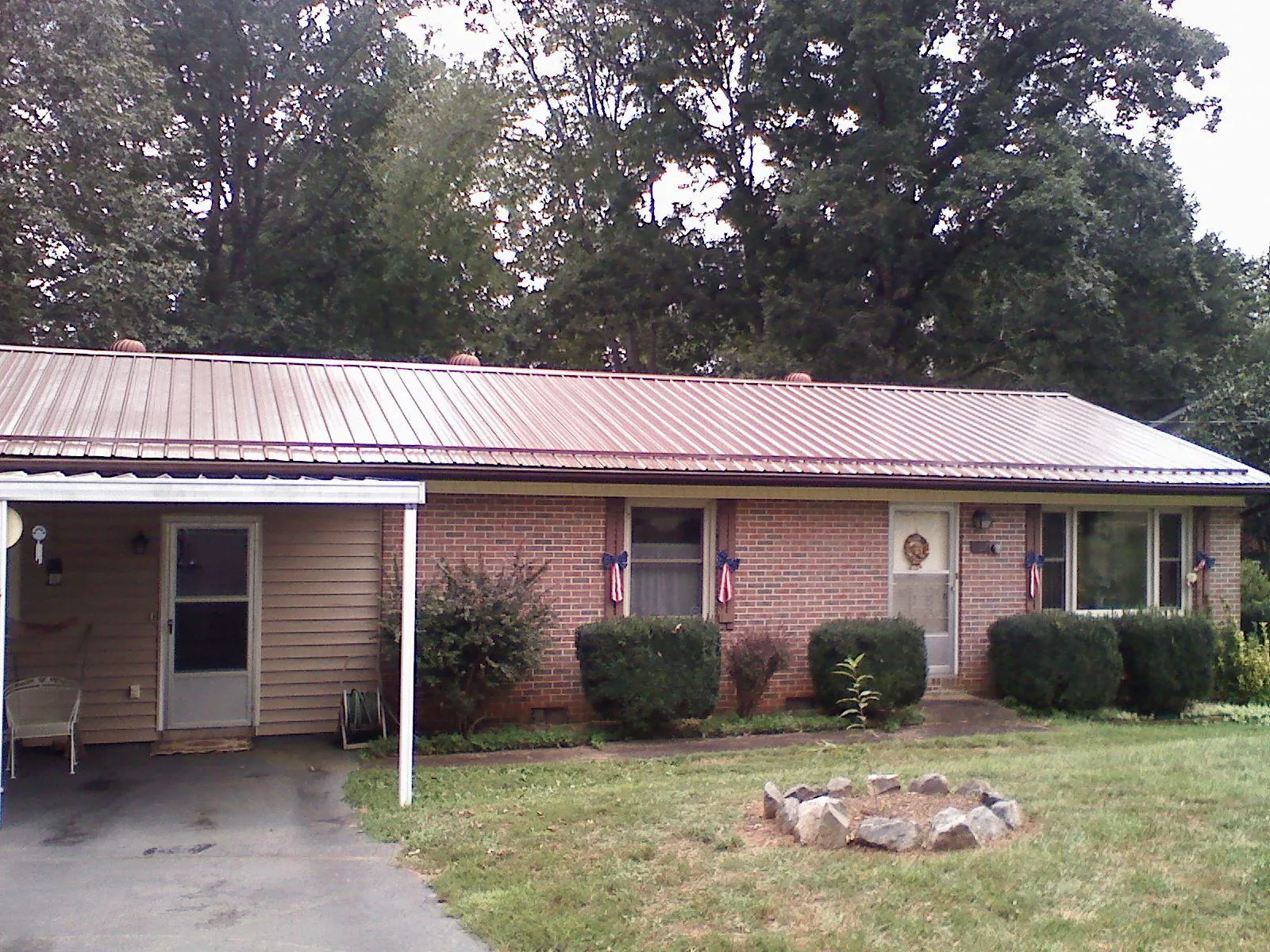 Bronze metal roof and carport on a brick ranch home — Roof Repair work by our crew in Conway